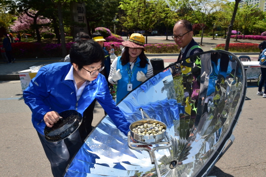 염태영 수원시장이 지난해 열린 지구의 날 기념행사에서 태양열 조리기 ‘쏠라쿠커’를 체험하고 있다.
