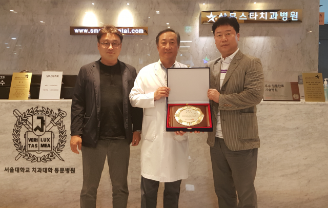 광주상무스타치과병원 양승필 병원장(가운데)이 KBC광주방송으로부터 감사패를 수상하고 기념 촬영 모습