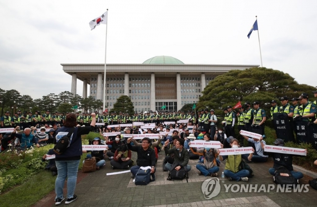민주노총 조합원들이 21일 국회에서 최저임금산입범위 확대 저지를 주장하고 있다. 사진=연합뉴스 제공