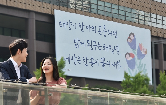‘광화문글판’ 여름편이 게시된 서울 광화문 교보생명 본사 앞에서 시민들이 밝게 웃고 있다. 사진=교보생명