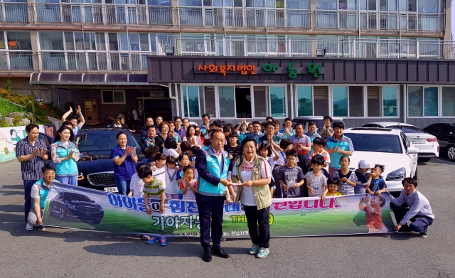9일(토) 목포 아동원 어린이들과 영화관람 행사를 앞두고 기아차 전남지역본부 정장근 본부장(앞줄 왼쪽)이 목포 아동원에 후원금을 전달하는 모습