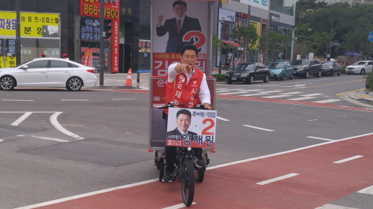  자전거 유세 중인 김재원 인천시의원 후보 기사의 사진