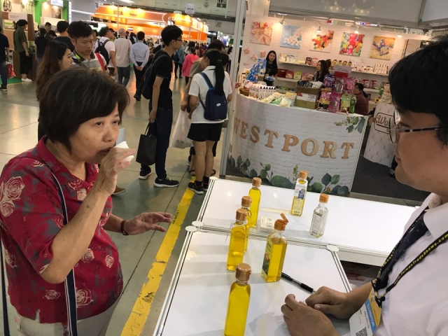 박람회에 출품된 생들기름을 시식하는 현지 관람객