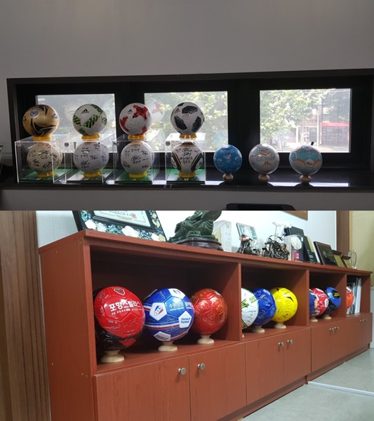 엄태건 대표이사실에 전시된 K리그 공식 축구공들(위), K리그 구단들의 축구공(아래)