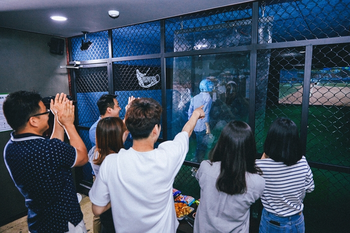 무더운 여름철, 스크린야구장 리얼야구존 방이점을 찾은 한 회사의 직장인들이 스크린야구를 즐기며 시원한 점심시간 회식을 진행하고 있다. 사진=리얼야구존 제공