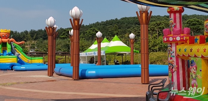 무안연꽃축제가 한창인 11일 더위를 식혀주기 위해 설치한 대형 어린이 물놀이 장이 햇빛을 차단하는 그늘 막은 물론 탈의실도 없어 파리만 날고 있다. (사진=뉴스웨이)