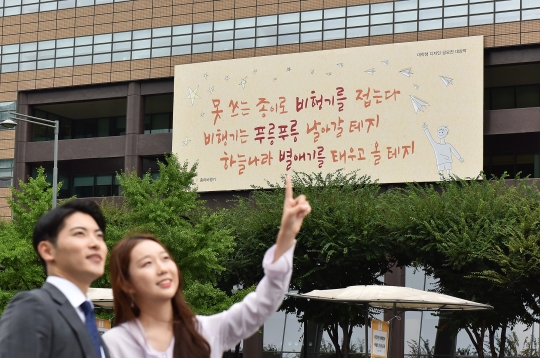 ‘광화문글판’ 가을편이 게시된 서울 광화문 교보생명 본사 앞에서 시민들이 밝게 웃고 있다. 사진=교보생명