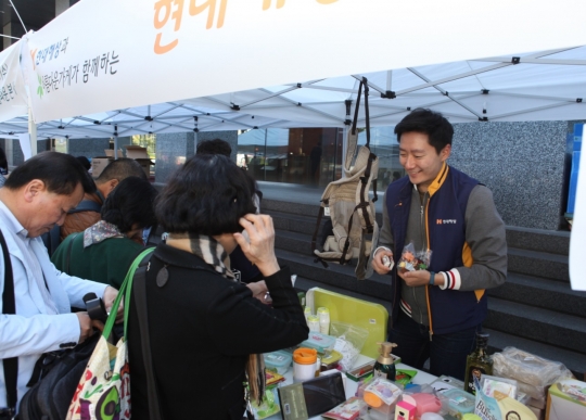 17일 서울 광화문 현대해상 본사 앞에서 진행된 자선바자회 ‘사랑나눔장터’에 참여한 현대해상 직원이 시민들에게 물품을 판매하고 있다. 사진=현대해상