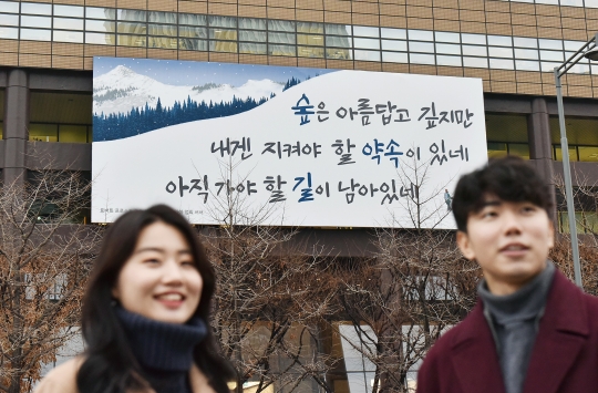 ‘광화문글판’ 겨울편이 게시된 서울 광화문 교보생명 본사 앞에서 시민들이 대화를 하고 있다. 사진=교보생명