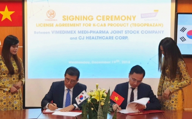 CJ헬스케어 강석희 대표(왼쪽)와 베트남 비메디멕스사 Cuong 대표(오른쪽)가 케이캡정 기술수출 계약서에 서명을 하고 있다. 사진=CJ헬스케어 제공