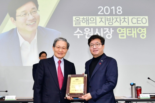 염태영 수원시장(오른쪽)이 박우서 한국공공자치연구원 이사장(왼쪽)에게 올해의 지방자치 CEO 선정패를 전달받고 기념촬영을 하고 있다.