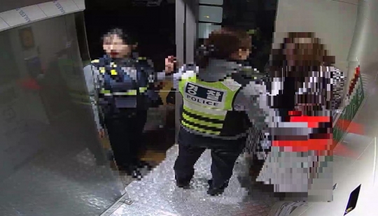 경찰이 안전부스에 들어온 여성을 보호하고 있다.