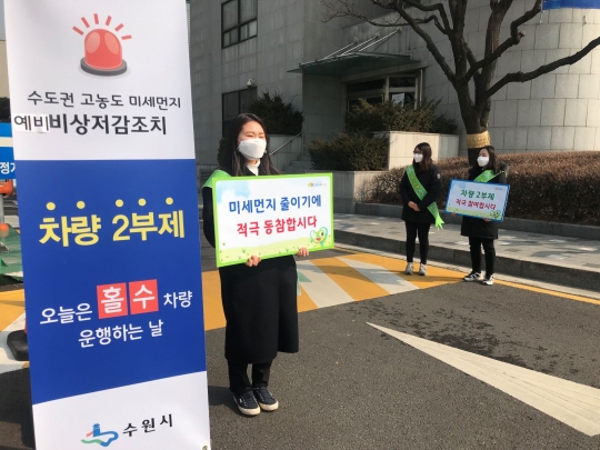 수원시 직원들이 21일 수원시청 주차장 입구에서 ‘행정‧공공기관 차량2부제’ 캠페인을 전개하고 있다.