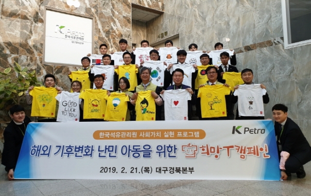 21일 한국석유관리원 손주석 이사장(첫줄 왼쪽에서 다섯 번째)과 직원들이 어린이들에게 보낼 T셔츠에 직접 그림과 메시지를 담은 후 기념촬영을 하고 있다.