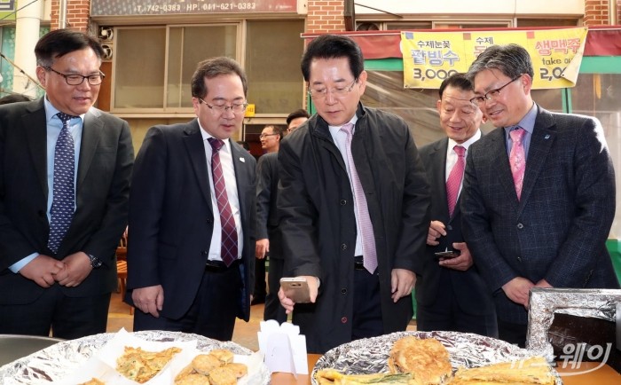 김영록 지사가 26일 순천 아랫장에서 제로페이로 물건을 구입하기 위해 모바일로 QR코드를 스캔하고 있다. 제로페이는 구매자가 물품을 구매하고 QR코드를 스캔하면, 사용자 계좌에서 소상공인 계좌로 직접 이체되는 간편 결제시스템으로 카드 수수료가 없다. (사진제공=전남도)