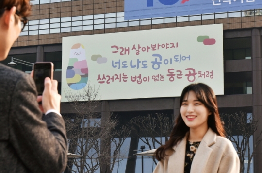‘광화문글판’ 봄편이 게시된 서울 광화문 교보생명 본사 앞에서 시민들이 사진을 촬영하고 있다. 사진=교보생명
