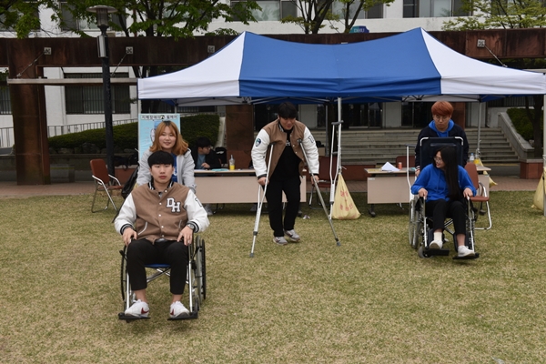 휠체어 이용 방법을 배우면서 지체장애 학우의 어려움을 체험하는 학생들(사진제공=대구한의대)