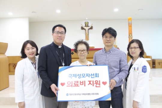 가톨릭관동대 국제성모병원 원목실장 김수현 신부(왼쪽 두 번째)와 교직원들이 김선영(가명)씨에게 의료비를 지원, 훈훈한 소식을 전했다.