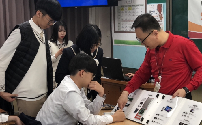 SK하이닉스가 이천 부원고등학교를 방문해 SKHU 행복교실을 개최하고 SK하이닉스 전임강사가 다양한 반도체 제품을 보여주며 각각의 쓰임새에 대해 설명하고 있다. 사진=SK하이닉스