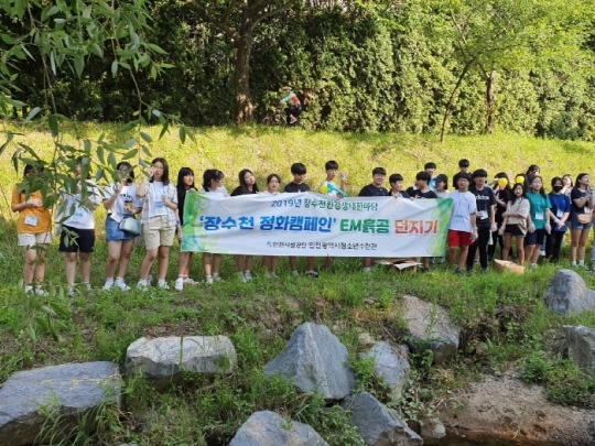 장수천에 EM흙공을 투척하는 환경 정화활동에 참가한 청소년들. 사진=인천시설공단