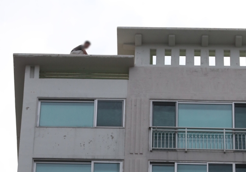 8일 오후 경남 거제시 옥포동 한 주상복합아파트 옥상에서 박모(45)씨가 경찰과 대치하고 있다. 사진=연합뉴스 제공