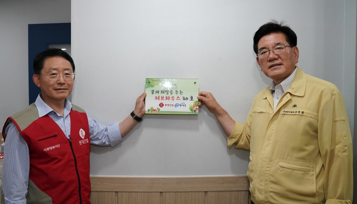 하석주 롯데건설 대표이사(좌측)와 유덕열 동대문구청 구청장(우측)이 러브하우스 봉사활동 기념 촬영을 하고 있다. 사진=롯데건설 제공