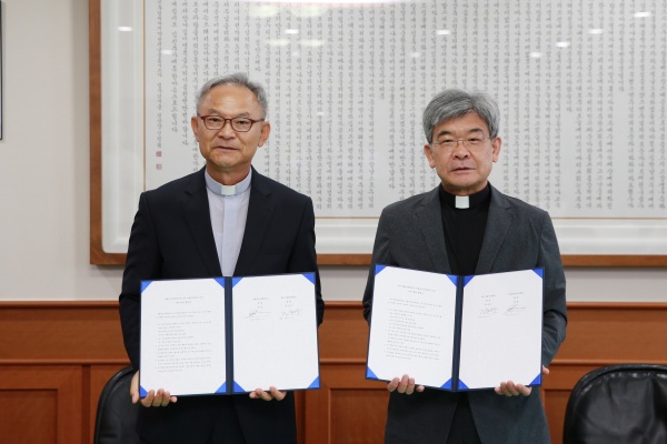 김정우 대구가톨릭대 총장(오른쪽)과 정일 가톨릭상지대 총장이 교류협정을 체결하고 협약서를 보이고 있다.(사진제공=대구카톨릭대)