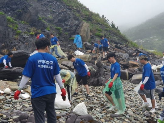 대청도로 섬 봉사활동을 떠난 인하대 학생들이 바닷물에 쓸려온 쓰레기를 수거하고 있다.