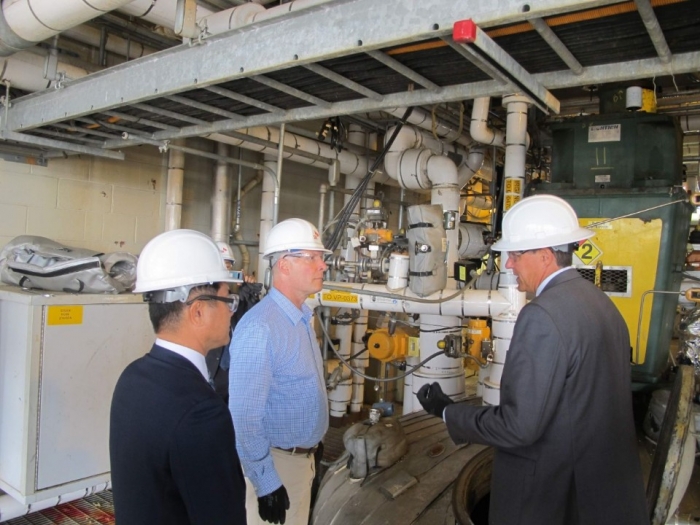 존 믈리나 美미시건주 하원의원(가운데)이 스티브 퍼사인 SKSA 공장장(오른쪽)으로부터 PVDC 생산 공정에 대한 설명을 듣고 있다. 왼쪽은 김종현 SK종합화학 미국법인 대표. 사진=SK종합화학 제공