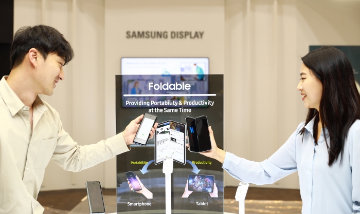 삼성디스플레이 직원들이 ‘IMID 2019’에서 폴더블 디스플레이를 채용한 ‘갤럭시 폴드’를 체험하고 있다. 사진=삼성디스플레이 제공