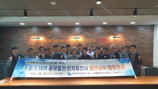 한국중부발전 기술전문원과 나래에너지서비스 O&M 관계자들이 터빈을 점검하고 기념촬영을 하고 있다.