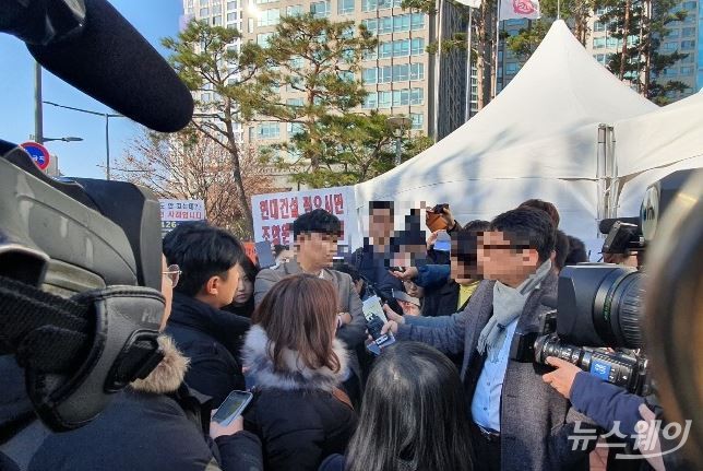 28일 오후 한남3구역 임시 총회가 열린 서울 용산구 천복궁가정교회 앞에서 한 조합원이 언론의 질의에 답하고 있다. 사진=이수정 기자