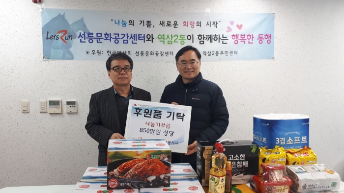 마사회 선릉지사 전정하 지사장이 역삼2동 주민센터 윤두현 동장에게 기부 물품을 전달하고 있다.