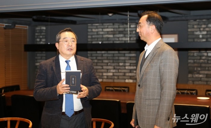 구자열 회장이 신규 임원이 된 LS전선 박현호 이사(LSCI법인장)에게 책을 선물하고 있다. 사진=LS그룹 제공