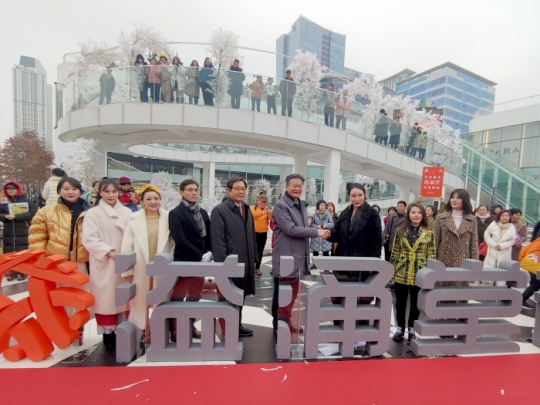 8일 중국 선양에 본사를 둔 건강웰빙식품 판매기업 이융탕(溢涌堂) 직원들이 인천시 연수구 송도국제도시의 대형 쇼핑몰에서 기념촬영을 하고 있다.