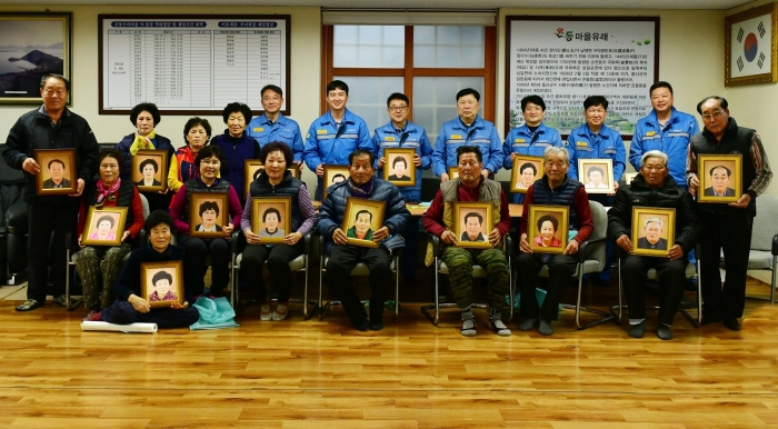 포스코 기술연구원 직원들이 7일 여수시 묘도동 마을 어르신들에게 장수사진 전달식을 갖고 있다.