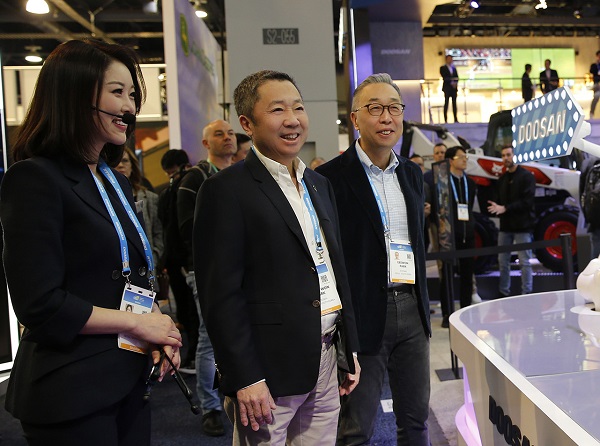 박정원 두산그룹 회장(사진 가운데)과 박지원 두산중공업 부회장(오른쪽)이 지난해 미국 라스베이거스에서 열린 ‘CES 2020’ 현장을 방문했다. 사진=두산 제공