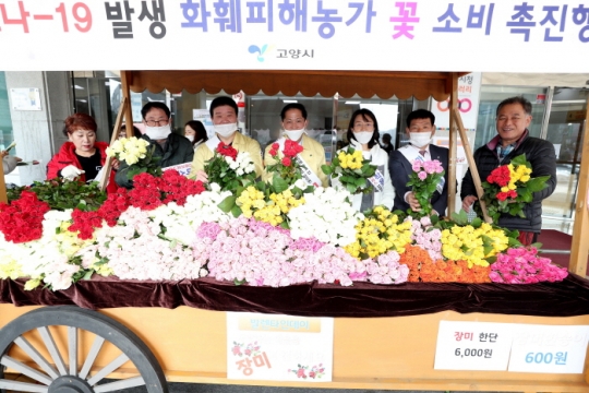 14일 이재준 고양시장(가운데)이 시청 현관 앞에 마련된 꽃마차에서 꽃 선물을 권하고 있다.