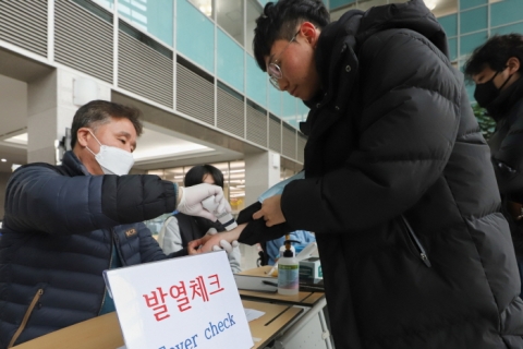 21일 인하대 정석학술정보관 담당자들이 도서관에 입장하는 학생들의 열을 확인하고 있다.