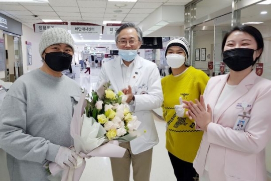 회복을 기념해 꽃을 전달받고있는 칭바트(좌)와 김동식 교수, 사르나이(오른쪽 2번째)