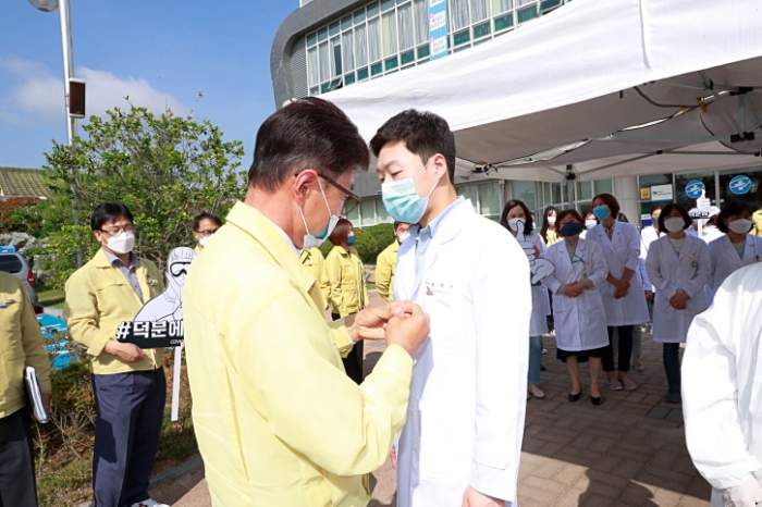 김철우 보성군수가 4일 보건소를 방문해 코로나19 감염증 대응에 헌신하고 있는 의료진에게 ‘덕분에 배지’를 달아주고 있다.