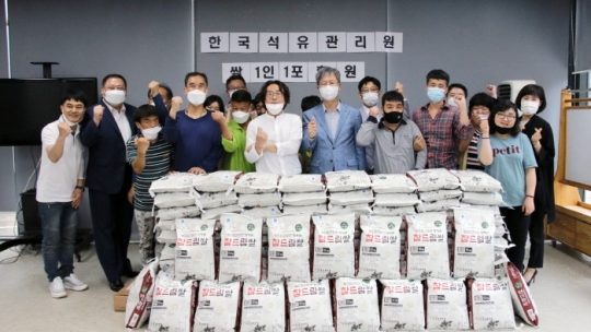 24일 한국석유관리원 손주석 이사장(오른쪽에서 네 번째)이 교남어유지동산에 쌀을 기부하고 기념촬영을 하고 있다.