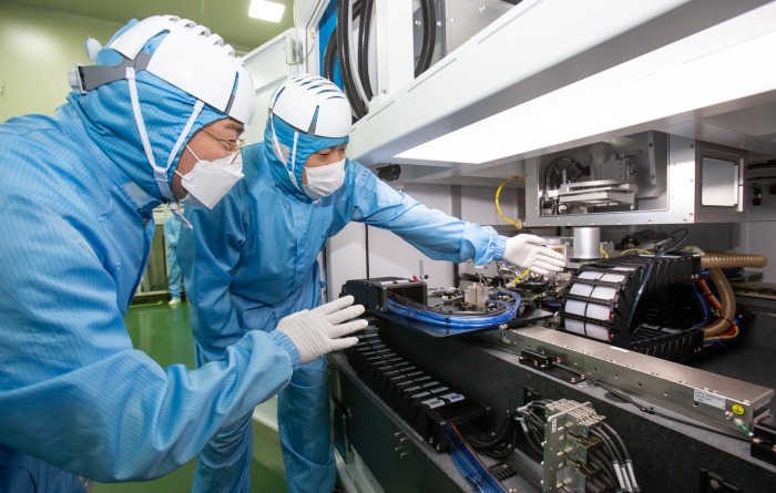 삼성전자 직원(좌)과 이오테크닉스 직원(우)이 양사가 공동 개발한 반도체 레이저 설비를 함께 살펴보고 있다. 사진=삼성전자 제공