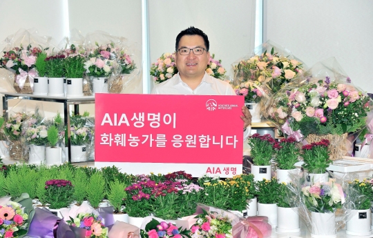 화훼 농가를 돕기 위해 ‘플라워 버킷 챌린지(Flower Bucket Challenge)’에 참여한 피터 정(Peter Chung) AIA생명 대표가 기념촬영을 하고 있다. 사진=AIA생명