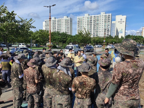 김종식 목포시장이 9일 이번 폭우에 영산강 상류 지역에서 목포 앞바다로 떠내려 온 해양쓰레기 수거 작업을 하는 군부대 장병들과 작업인부들을 격려하고 있다.