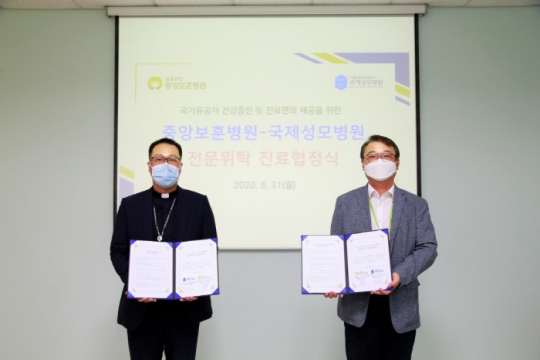 31일 국제성모병원 김수현 관리실장(왼쪽)과 중앙보훈병원 양치현 원무부장이 업무협약 체결 후 기념촬영을 하고 있다.