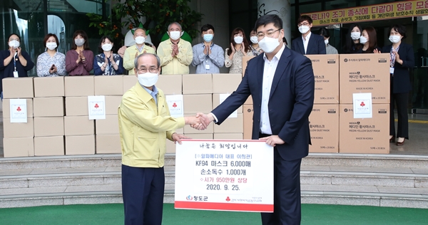 ㈜알파메디아 이희관 대표가 이승율 청도군수(왼쪽)에게 마스크와 손소독제를 기탁하고 기념사진을 찍고있다.(사진제공=청도군)