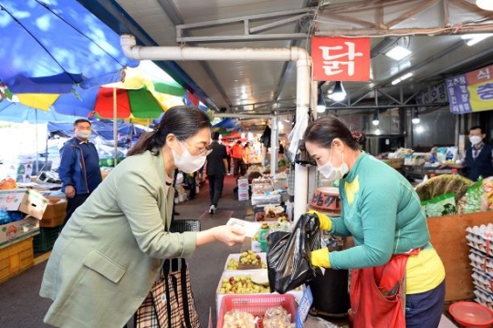 은수미 성남시장이 전통시장에서 지역상품권으로 물건값을 치르고 있다