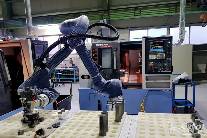 ㈜두산이 협력사 스마트공장 구축을 위해 도입한 협동로봇이 생산현장에서 작업을 수행하고 있다. 사진=두산 제공
