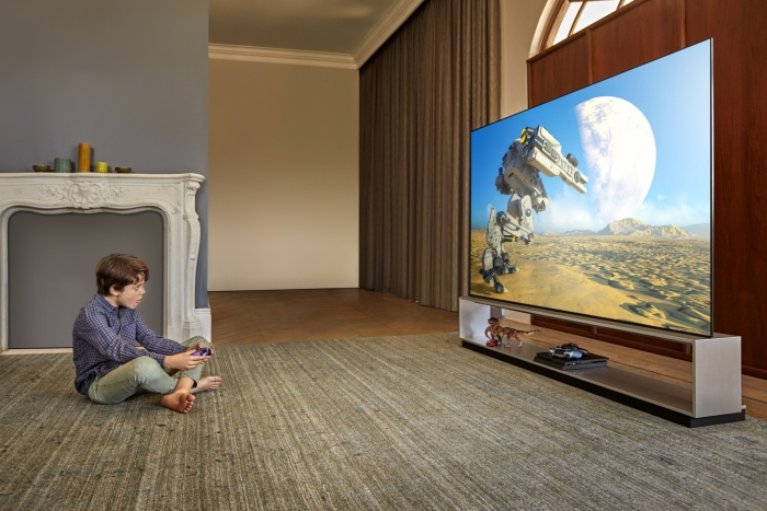 모델이 LG 올레드 TV(모델명: ZX)를 활용해 게임을 즐기고 있다. 사진=LG전자 제공